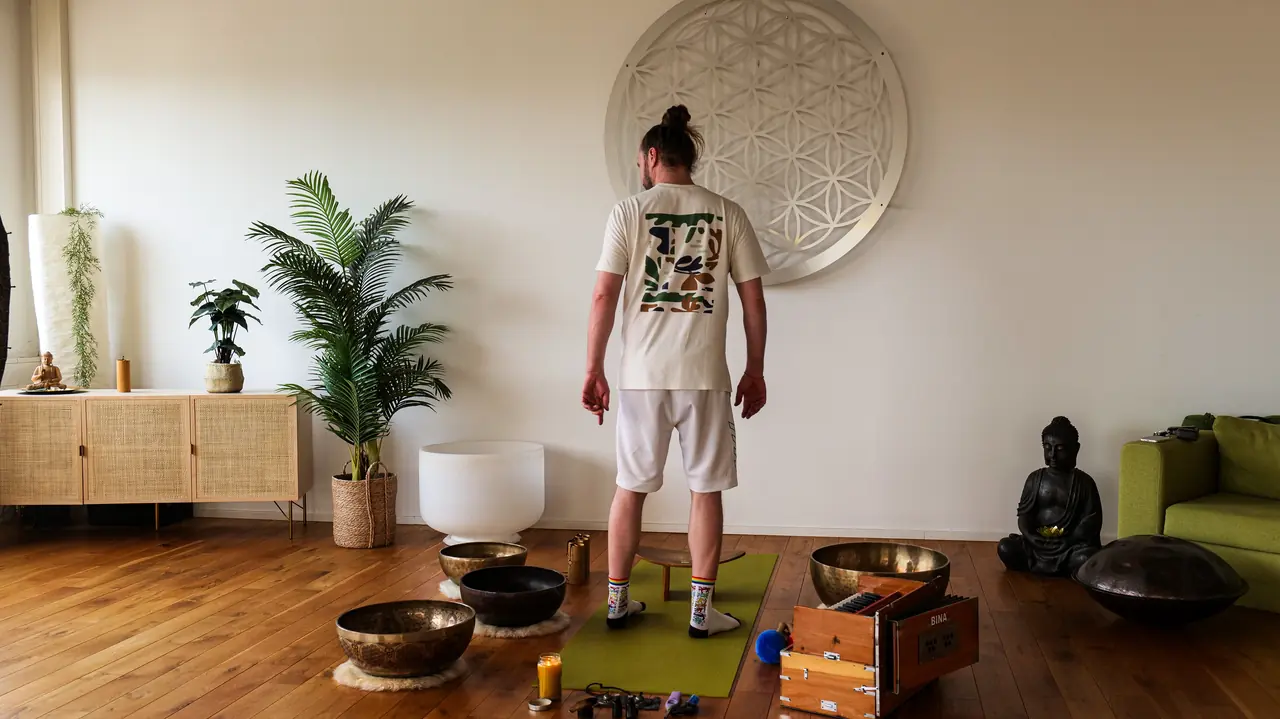 Michi Willkommen steht von hinten vor der Blume des Lebens im Studio.